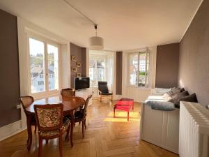 a living room with a table and a couch at Le Locle : bel appartement chaleureux in Le Locle