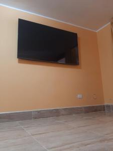 a flat screen tv on the corner of a wall at Casa La Ruta Jardines in Pisco