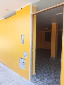 an empty room with a yellow wall at Casa La Ruta Jardines in Pisco