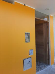 una pared amarilla en una habitación con puerta en Casa La Ruta Jardines, en Pisco