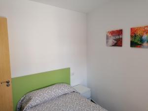 een slaapkamer met een bed en twee schilderijen aan de muur bij Alojamiento Las Dunas Bajo in Tabernas