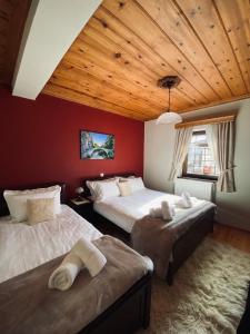 Zagori Home في مونوديندري: غرفة نوم بسريرين وسقف خشبي