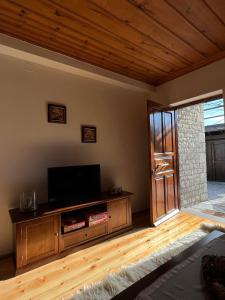 a living room with a flat screen tv and a door at Zagori Home in Monodendri