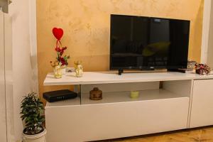 a tv on a white entertainment center with a television at Apartman Lada in Bijeljina