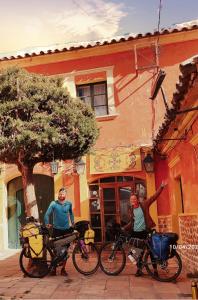 dos hombres parados con sus bicicletas delante de un edificio en Casa de Huéspedes María Victoria, en Potosí
