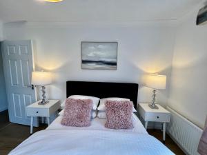 a bedroom with a bed with pillows and two lamps at Central Cambridge Fig Tree house in Cambridge