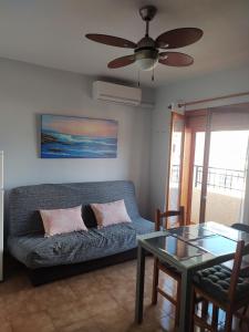 ein Wohnzimmer mit einem Sofa und einem Tisch in der Unterkunft Apartamento Paraiso in Santa Pola
