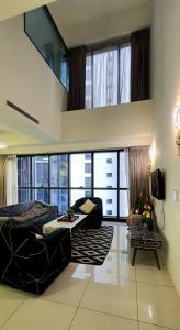 een woonkamer met een bank en een groot raam bij M City Ampang Infinity Pool KLCC in Kuala Lumpur