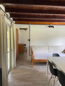 a bedroom with a bed and a table with chairs at La Franca Cabaña de Veraneo in Villa General Belgrano