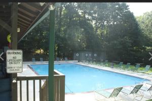 ein Pool mit Stühlen und ein Schild daneben in der Unterkunft Peaceful Modern Chalet in Ellijay in Ellijay