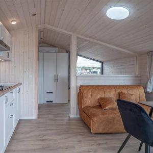 a living room with a couch and a table at Twin Boats - M Cabin in Mingė