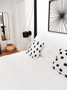 a bedroom with a white bed with black pillows at The Idyll Boutique Apartment - Spanish Quarter in Naples