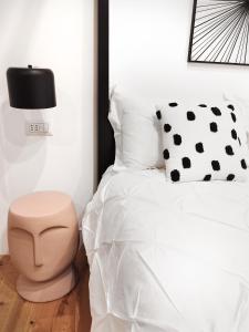 a bedroom with a white bed and a black and white pillow at The Idyll Boutique Apartment - Spanish Quarter in Naples