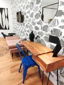 een woonkamer met een houten tafel en een blauwe stoel bij The Idyll Boutique Apartment - Spanish Quarter in Napels