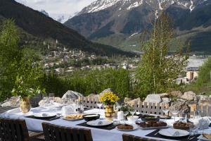 stół z jedzeniem na nim z górami w tle w obiekcie Sami Mta Chalet w mieście Mestia