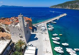 a group of boats in the water next to a pier at Apartman Škor in Komiža