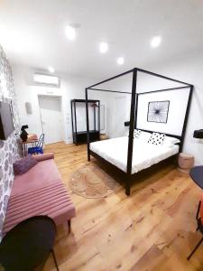 una camera con letto a baldacchino nero e pavimento in legno di The Idyll Boutique Apartment - Spanish Quarter a Napoli