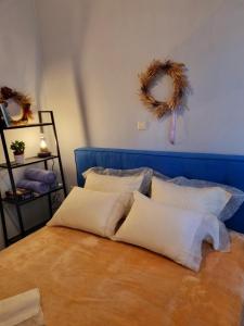 a bed with white pillows and a blue head board at City Life Metro Ambelokipi in Athens