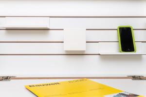 a cell phone on a shelf with a yellow paper at Seminarhaus S1516 in Berlin