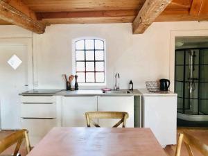 a kitchen with a table and a sink and a window at Summer House In Rural Surroundings On Bornholm in Svaneke