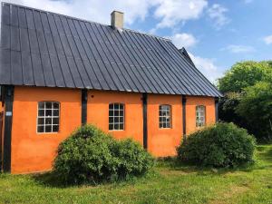 an orange house with a black roof at Summer House Svaneke in Svaneke