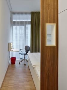 1 dormitorio con cama, escritorio y silla en Seminarhaus S1516 en Berlín