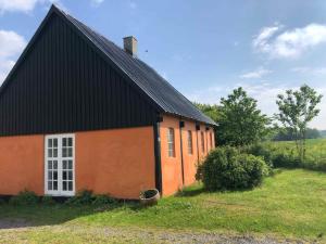 a small orange building with a black roof at Summer House Svaneke in Svaneke