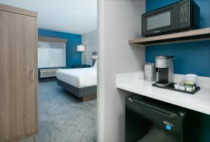 a hotel room with a bed and a microwave at Holiday Inn Express & Suites - Dallas Park Central Northeast, an IHG Hotel in Dallas