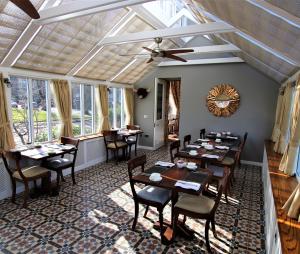 a dining room with tables and chairs and windows at Victoria Square & The Orangery in Stirling