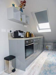 a kitchen with a sink and a stove with a window at Blackberry Loft - a Hidden Gem in Templepatrick