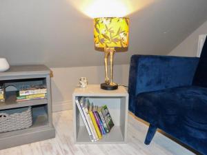 a lamp on a table next to a blue chair at Blackberry Loft - a Hidden Gem in Templepatrick