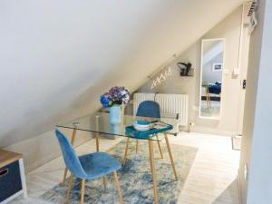 a dining room with a glass table and blue chairs at Blackberry Loft - a Hidden Gem in Templepatrick