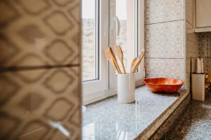 a kitchen counter with a bowl and wooden utensils at Forno House - O Lagar in Vila Praia de Âncora +20 photos