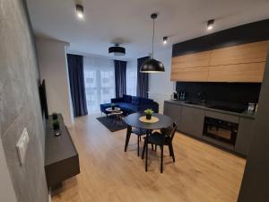 kuchnia i salon ze stołem i krzesłami w obiekcie Premium Apartments Rzeszów Silver w mieście Rzeszów