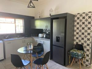 a kitchen with a table and chairs and a refrigerator at Boma choma in Beaufort West