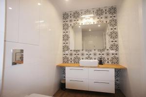 een badkamer met een wastafel en een spiegel bij Drzewna Apartamenty -Augustowska in Zielona Góra