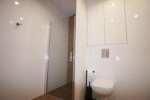 biała łazienka z toaletą i prysznicem w obiekcie Drzewna Apartamenty -Augustowska w Zielonej Górze