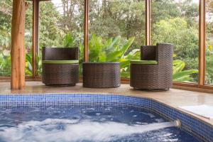 a jacuzzi tub in a room with windows at Hotel Belmar in Monteverde Costa Rica