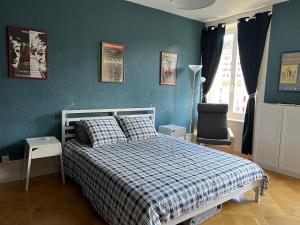 sypialnia z łóżkiem i niebieską ścianą w obiekcie Le Locle : bel appartement chaleureux w mieście Le Locle