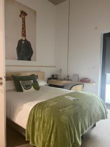 1 dormitorio con 1 cama con una foto de jirafa en la pared en Le B Complexe Hôtel en Lozanne