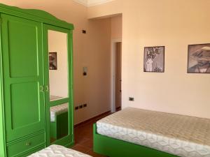 a bedroom with a green cabinet and a bed at Maison sur plage in Al Ḩammām