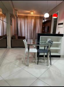 a dining room with a glass table and two chairs at Fortaleza Landscape Beira-mar: espaço inteiro in Fortaleza