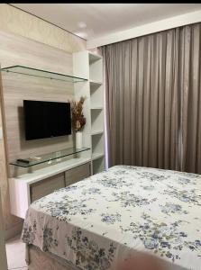 a bedroom with a bed and a tv on a wall at Fortaleza Landscape Beira-mar: espaço inteiro in Fortaleza