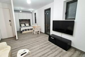 a living room with a bed and a flat screen tv at Barcelona Beach Studio in Barcelona