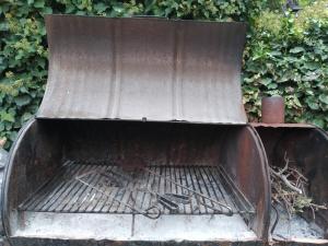 Een oude grill met gereedschap erin. bij Mini casa in Chacras de Coria