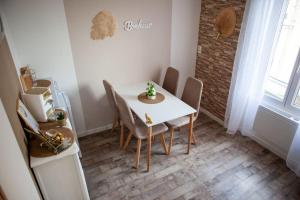 une salle à manger avec une table et des chaises blanches dans l'établissement Appartement Un moment d’ÉVAsion, à Épernay