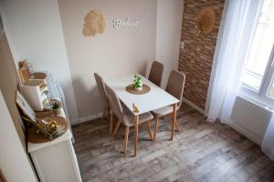 jadalnia z białym stołem i krzesłami w obiekcie Appartement Un moment d’ÉVAsion w Épernay
