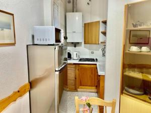 uma pequena cozinha com frigorífico e micro-ondas em Sea at 400mt - station - wi-fi em Laigueglia