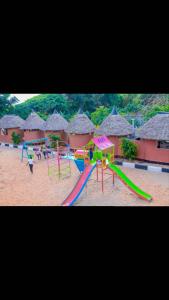 a playground on a beach with huts at Jambo Afrika Resort in Emali