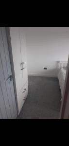 a white cabinet in a room with a bed at Short and Long Night Stay - very close to Gatwick and City Centre - Private Airport Holiday Parking - Early Late Check-ins in Crawley